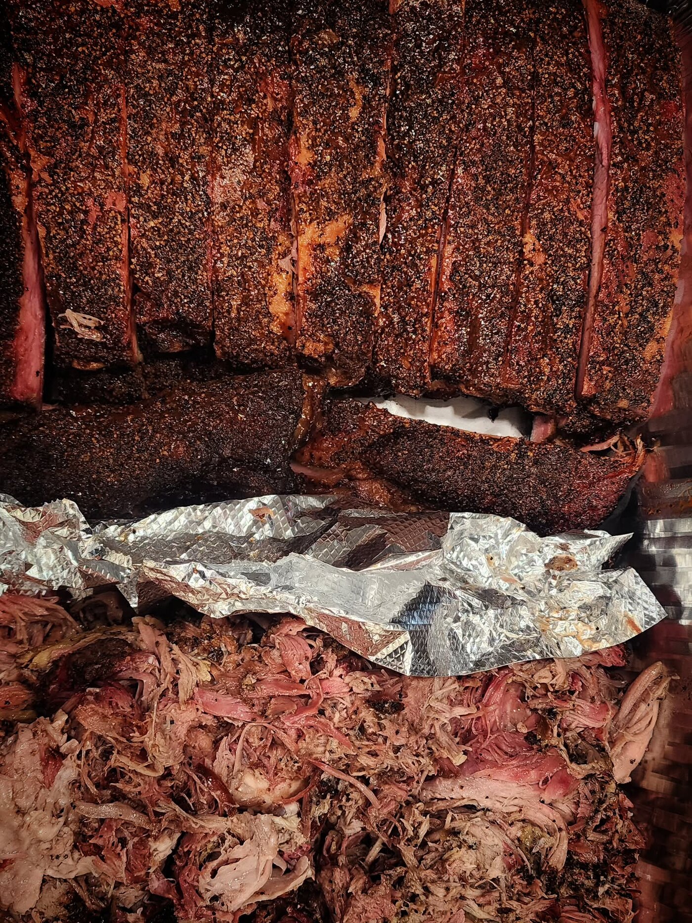 Racks of pork ribs above a bed of pulled pork